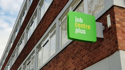 The square green Job Center Plus sign attached to the outside wall of the office building